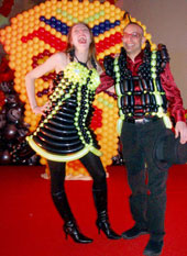 Un couple d'artistes ballooneurs habillés de costumes fabriqués de ballons aux couleurs acidulees lancent la soiree et le defile dans l'alegresse