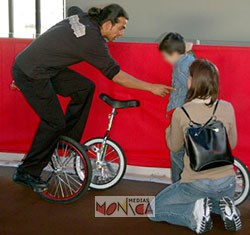 Un animateur et artiste de cirque va initier un enfant devant sa maman à la discipline du monocycle