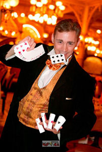 Le magicien Herve en spectacle fait apparaitre des tourbillons de cartes entre ses doigts de prestidigitateur celebre