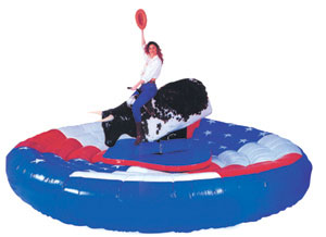 Cow-girl sur taureau mecanique lors d un jeu de rodeo sur matelas gonflable