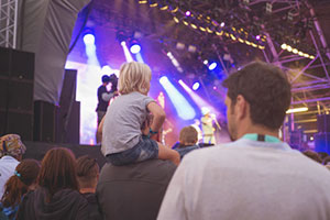 Un enfant venu sur les epaules de son pere assister à un concert jeune public