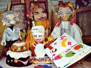 Famille de marionnettes apprenant la cuisine et la patisserie autour d'un livre de recettes imagees