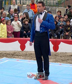 Monsieur Loyal en costume presentant les numeros au milieu de la piste d'un cirque de plein air