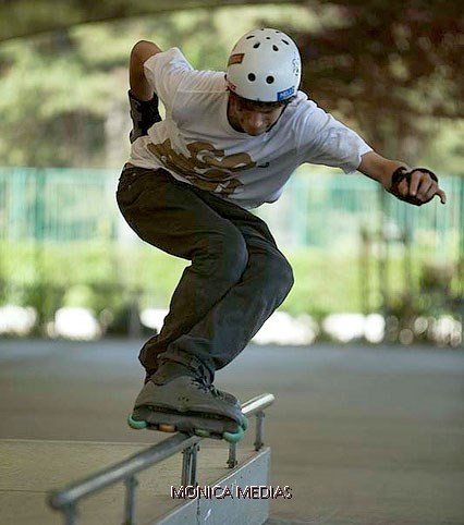 Un pratiquant de freestyle roller glisse sur une rampe metallique pres du sol