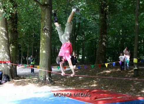 Un pratiquant de slackline se tient sur la corde les bras tendus avec les jambes en equilibre