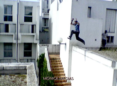 Un pratiquant de parkour et de profil realise un saut depuis un toit d'immeuble