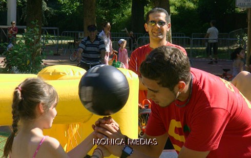 Une enfant fait tourner un ballon de foot avec un freestyleur professionnel lors d'une initiation de football freestyle