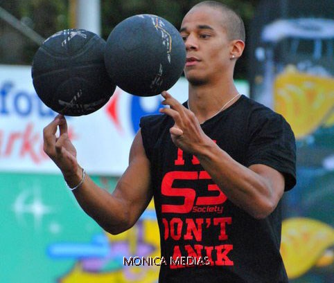 Un professionnel de street basket maitrise deux ballons de basketball en meme temps du bout des doigts