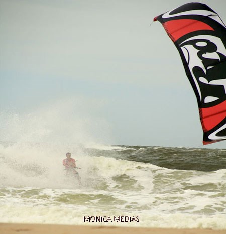 Un professionnel de kiteboard glisse sur des eaux mouvementees par un temps tres gris