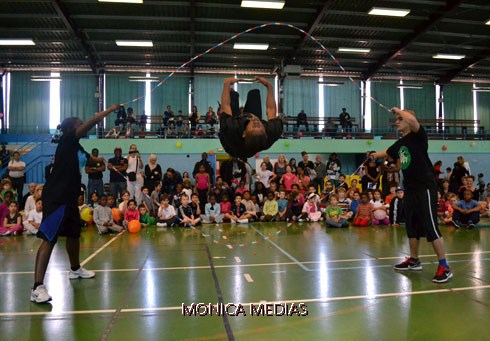 Deux tourneurs pemettent a un sauteur de realiser un salto entre deux cordes pour une demonstration en interieur