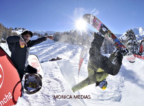 Un snowboarder en plein vol les bras ecartes apres la realisation d'une figure acrobatique