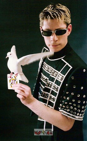 Cet artiste magicien tient une carte sur sa main gauche avec une colombe au dessus de la carte